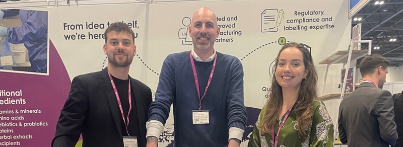 3 team members at a reception desk at an industry exhibition